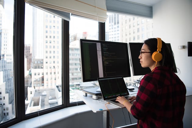 Woman standing While Operating Macbook Pro