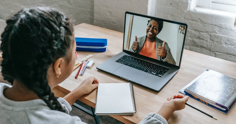 girl having video chat with teacher online on laptop