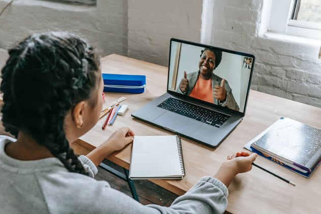 girl having video chat with teacher online on laptop
