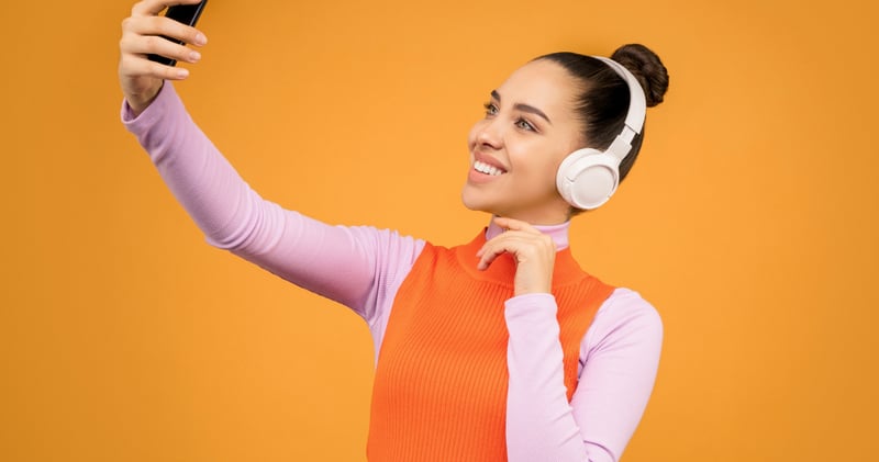 Woman in Knitted Long Sleeve Shirt Holding Black Mobile Phone
