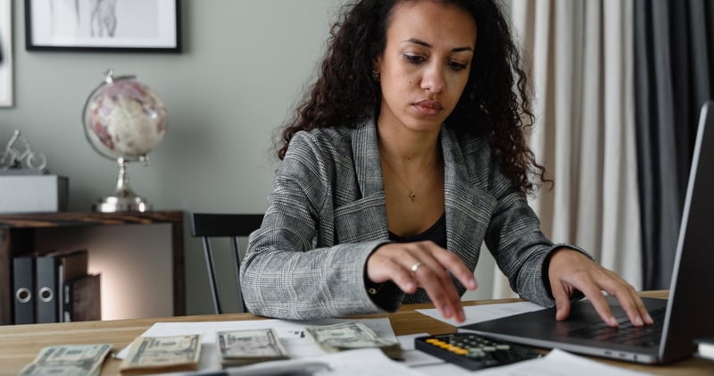 A Woman in Plaid Blazer Using Her Laptop and Mobile Phone