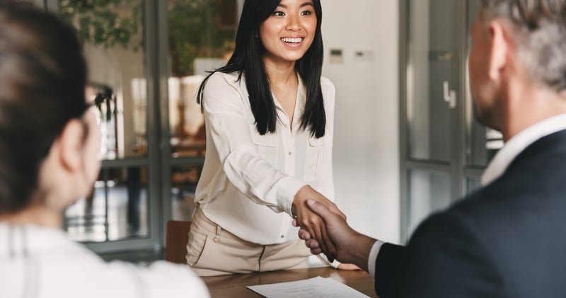 Woman shaking hands across the interview table