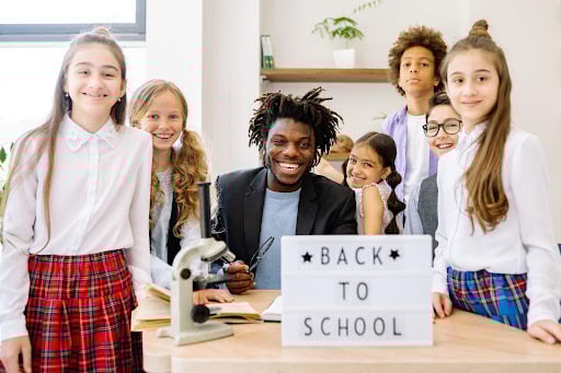 Teacher with students around desk