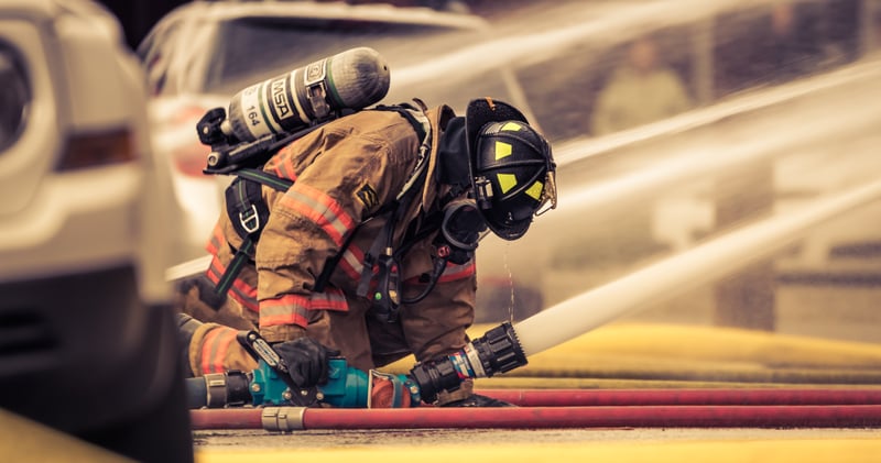 Firefighter Holding Hose with Water Flowing