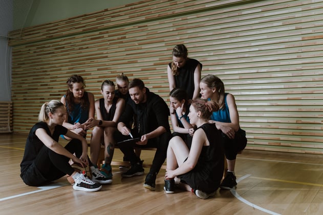 A Man Coaching a Team of Women
