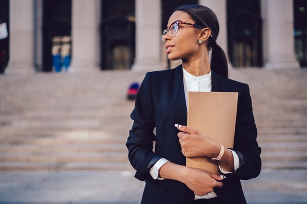 Woman carrying a folder in front of steps