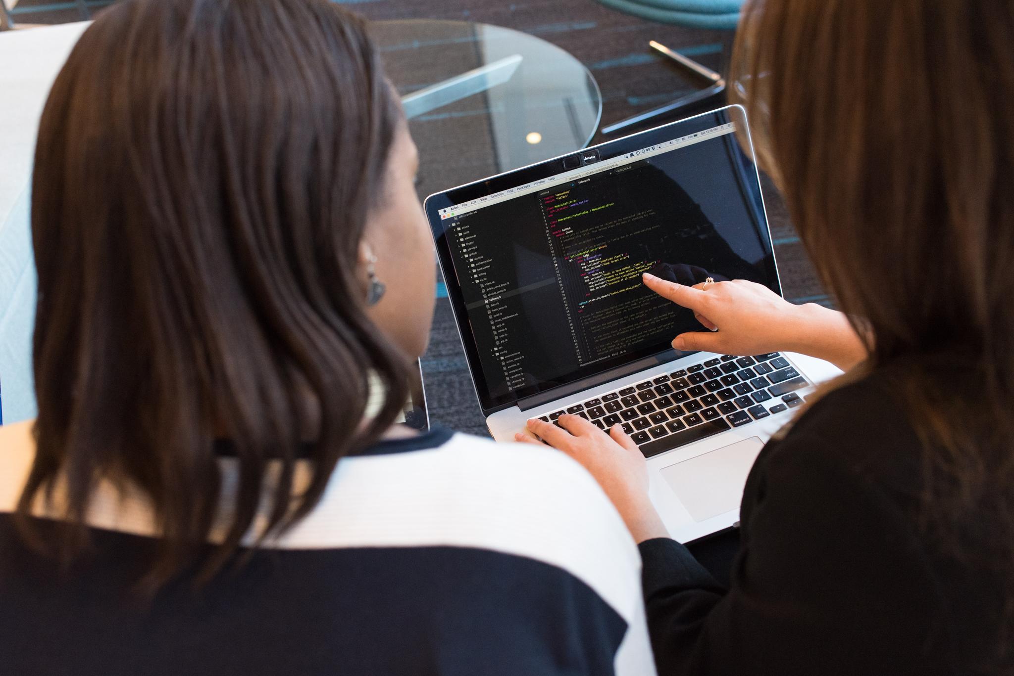 Two women reviewing code on a laptop, from the software engineer resume guide